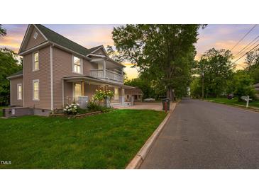 Charming two-story home with a welcoming front porch and well-maintained lawn at sunset at 223 Hall Ave, Burlington, NC 27217