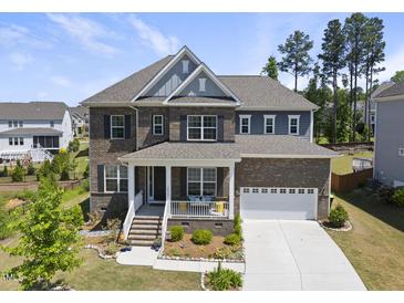 Charming two-story home with a beautifully landscaped front yard and a welcoming covered front porch at 2527 Sidewinder Ct, Apex, NC 27523