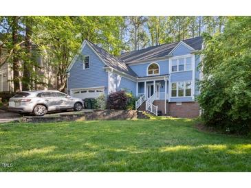 Charming two-story home with light blue siding, well-maintained lawn, and an attached two-car garage at 307 Durington Pl, Cary, NC 27518