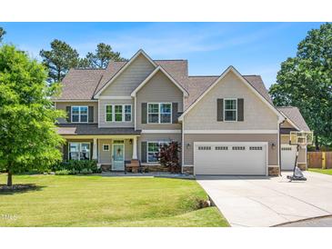 Traditional two-story home with a two car garage, a basketball hoop, and well-maintained landscaping at 311 Ocean Dr, Clayton, NC 27520