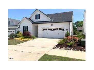 Charming home featuring a two-car garage, well-maintained landscaping, and classic white siding at 3521 Olive Glen Dr, Apex, NC 27502