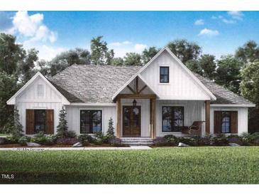 Charming white farmhouse featuring a beautiful porch, shingled roof, and professionally landscaped front yard at 5021 Mitchell Town Rd, Youngsville, NC 27596