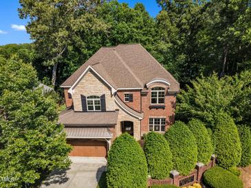 Beautiful brick and stone home with mature trees and manicured landscaping at 5600 Bennettwood Ct, Raleigh, NC 27612