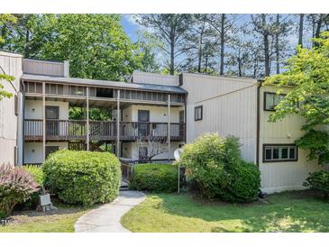 Exterior of a two-story condo unit with wood siding, screened porches, and landscaped walkway and lawn at 629 Pine Ridge Pl, Raleigh, NC 27609