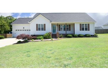 Charming home featuring a manicured lawn and a welcoming front porch with brick accents at 74 Pedernales Dr, Smithfield, NC 27577