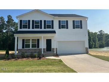 Charming two-story home with a traditional design, white siding, dark shutters, and a well-manicured lawn at 85 Cordoba Dr, Franklinton, NC 27525