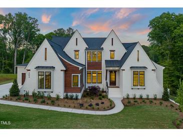 Striking two-story home boasts a white brick facade complemented by elegant black trim and a meticulously landscaped front yard at 9004 Meadow Pointe Ct, Wake Forest, NC 27587