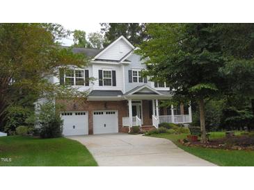 Charming two-story home featuring a two-car garage, brick accents, and a welcoming front porch at 106 N Duelling Oaks Dr, Chapel Hill, NC 27517