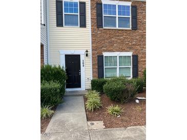 Charming townhouse with a black front door, manicured bushes, and a mix of stone and siding exterior at 1304 Cozart St # 109, Durham, NC 27704
