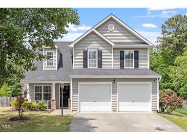 Charming two-story home featuring a two-car garage, complemented by a well-manicured front lawn and lush landscaping at 15 Epping Ct, Durham, NC 27703