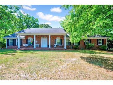 Charming brick home with a large, covered front porch and well-manicured lawn at 206 Kittys Ln, Erwin, NC 28339