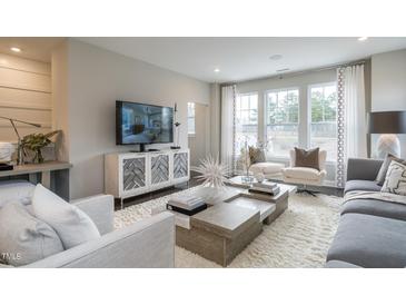 Modern living room with large windows, plush seating, area rug, and entertainment center at 2301 Bay Minette Sta # 538, Apex, NC 27502