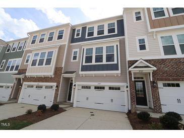 View of townhomes featuring a two-car garage and a mix of siding and stone on the facade at 2323 Hunter Woods Dr # 566, Apex, NC 27502