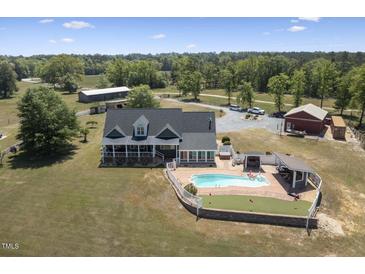 Expansive property featuring a charming home, pool, outdoor kitchen, barn, and scenic surroundings at 3636-A Holly Grove Rd, Dunn, NC 28334