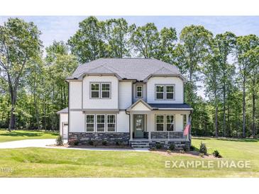 Charming two-story home featuring stone accents, inviting porch, and a well-manicured lawn at 440 Golden Dragonfly St, Wake Forest, NC 27587