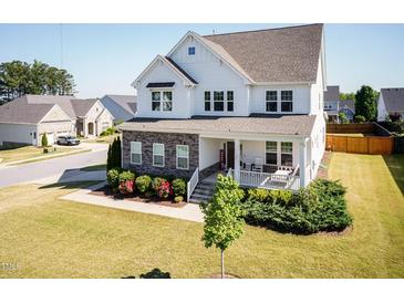 Charming two-story home boasts a welcoming front porch, beautiful landscaping, and a well-manicured lawn at 536 Adkins Ridge Rd, Rolesville, NC 27571