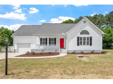 Charming home with white siding, black shutters, red front door and well-manicured landscaping at 5612 Sandy Trail Dr, Knightdale, NC 27545