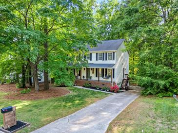 Charming two-story home featuring a welcoming front porch and a well-manicured front yard surrounded by mature trees at 5701 Hadrian Dr Dr, Durham, NC 27703