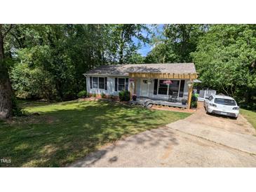 Charming home with a well-manicured lawn, a covered porch, and a paved driveway at 6125 Bellow St, Raleigh, NC 27609