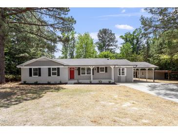 Charming one-story home featuring a red front door, gray brick, and a well-maintained yard at 7824 Knightdale Blvd, Knightdale, NC 27545