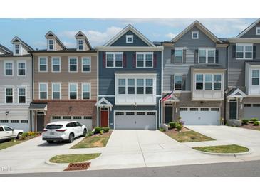 Modern townhomes feature multi-toned exteriors and attached garages with driveways at 805 Grafton Peak Lane Ln, Apex, NC 27523