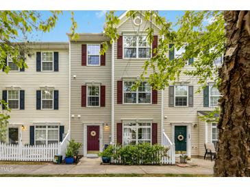 Charming townhome features a classic exterior with a picket fence and well-maintained landscaping at 8640 Neuse Landing Ln # 110, Raleigh, NC 27616