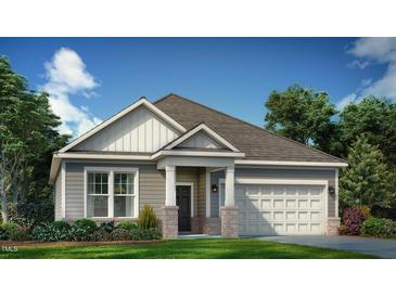 Charming single-story home featuring a two-car garage and craftsman-style details, set against a bright blue sky at 1033 Channel Drop Lp, Zebulon, NC 27597