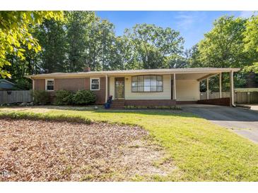 Charming single-story home with a brick facade, covered carport and mature landscaping at 108 Jefferson Dr, Durham, NC 27712
