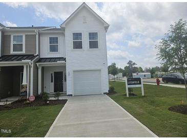 Charming two-story townhome with a one-car garage and well-manicured front lawn at 12 Lavender Ln, Clayton, NC 27520