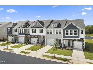 Charming townhomes with manicured lawns and attractive exteriors along a tree-lined street at 12 Lavender Ln, Clayton, NC 27520