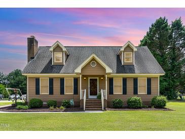 Charming Cape Cod-style home with dormers, black shutters, brick chimney, and a lush green lawn at 123 Sanders Road Rd, Benson, NC 27504