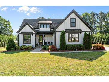 Charming two-story home with black trim, American flag, landscaped yard, and well-manicured lawn at 15 Willow Bend Dr, Youngsville, NC 27596