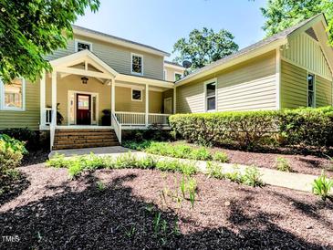 Inviting two-story home featuring a covered porch and meticulously landscaped front yard with a winding walkway at 1605 Park Dr, Raleigh, NC 27605