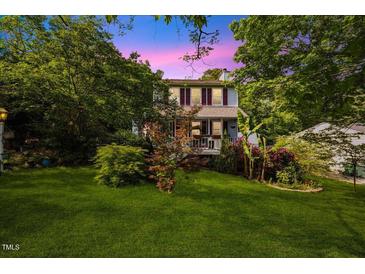 Charming two-story home with red shutters, lovely landscaping, and a lush lawn surrounded by mature trees at 1924 Strebor St, Durham, NC 27705