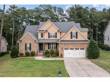 Charming two-story home with brick and tan siding, featuring a manicured lawn and a two-car garage at 200 Heather Brook Cir, Spring Lake, NC 28390