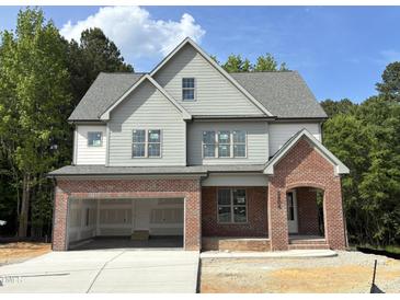 Charming two-story home with a brick-accented facade and attached two-car garage, surrounded by lush greenery at 2408 Eagle Shot Ct # 4, Fuquay Varina, NC 27526