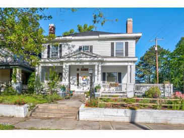 Charming two-story home featuring a welcoming front porch and well-maintained landscaped yard at 302 Villa St, Rocky Mount, NC 27804