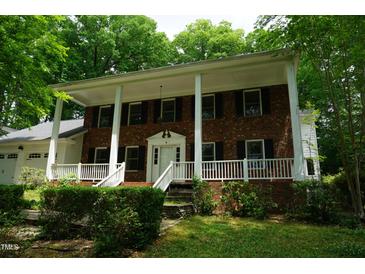 Charming brick home with a welcoming front porch and beautiful landscaping at 4113 Oak Park Rd, Raleigh, NC 27612
