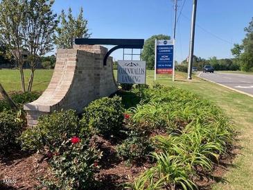 Community entrance sign with landscaping and sales information against a backdrop of lush greenery at 46 Black Walnut Dr # 197, Garner, NC 27529