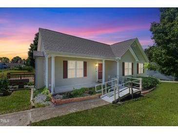 Charming one-story home features a ramp, manicured lawn, and beautiful twilight sky at 55 Ayden Dr, Clayton, NC 27520