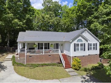 Charming home featuring a brick foundation, cozy porch, and well-maintained landscaping at 556 Margaret Pl, Garner, NC 27529
