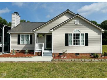 Charming single-story home with a metal roof, tidy landscaping, and an inviting front porch entrance at 1021 Forest Glen Dr, Raleigh, NC 27603