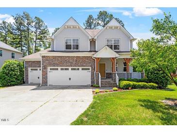 Charming two-story home boasts stone accents, a three-car garage, and a well-manicured lawn at 1613 Waddell Ct, Durham, NC 27703
