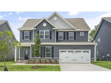 Charming two-story home with gray siding, black shutters, and a well-manicured front yard, perfect for curb appeal at 556 Lemon Daisy Ln, Knightdale, NC 27545
