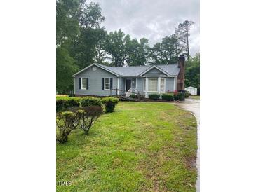 Charming single-story home features well-maintained landscaping, a quaint front porch, and a welcoming entrance at 6216 Krandon, Raleigh, NC 27603