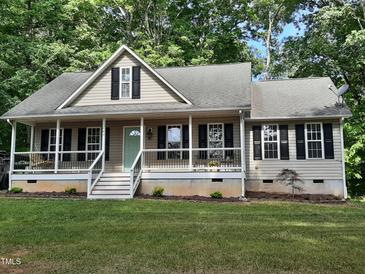 Charming single Gathering home boasting a cozy front porch, complemented by lush landscaping and mature trees at 640 Sagamore Dr, Louisburg, NC 27549