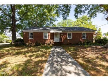 Charming brick home with a well-maintained lawn and a concrete walkway leading to the front door at 210 S Hughes St, Apex, NC 27502