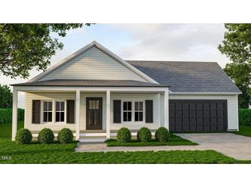 Charming single-story home with covered porch, black shutters, and attached garage at 214 Green Pines Estates Dr, Kenly, NC 27542