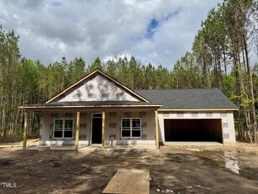 New construction single story home featuring an attached garage and a covered front porch at 214 Green Pines Estates Dr, Kenly, NC 27542
