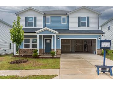 Charming two-story home with an attached two-car garage, landscaped yard, and a partially brick facade at 2226 Cherry Creek Rd, Haw River, NC 27258
